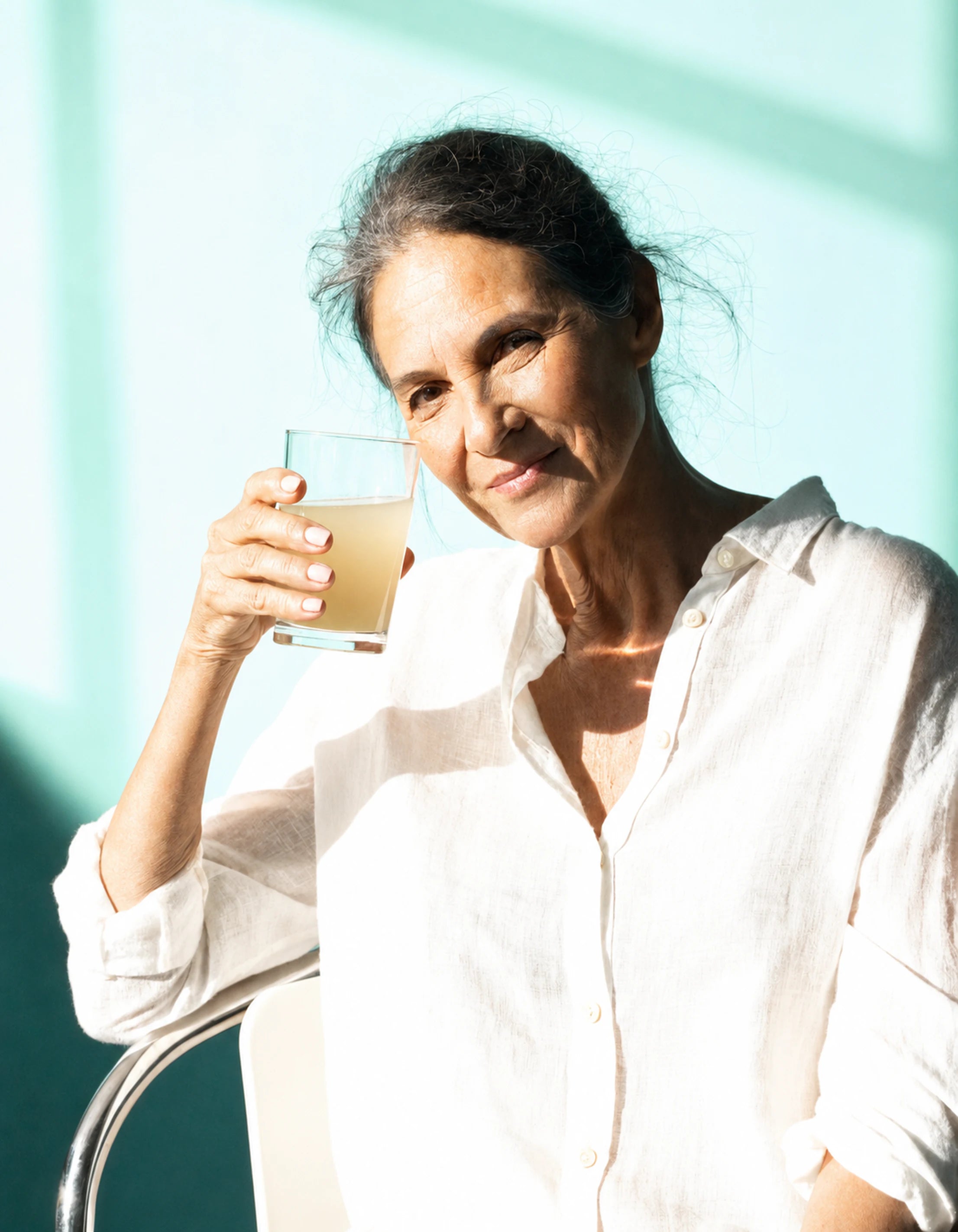 Woman holding a glass as part of her everyday wellness routine